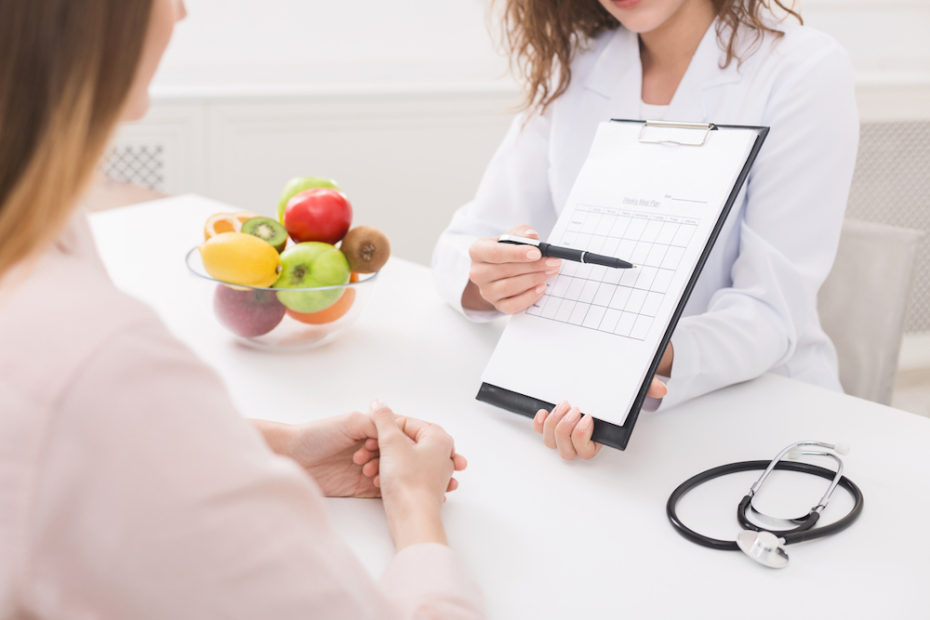 Food coaching. Professional dietitian explaining meal plan to patient at consultation